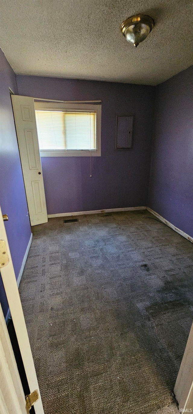 carpeted spare room featuring a textured ceiling