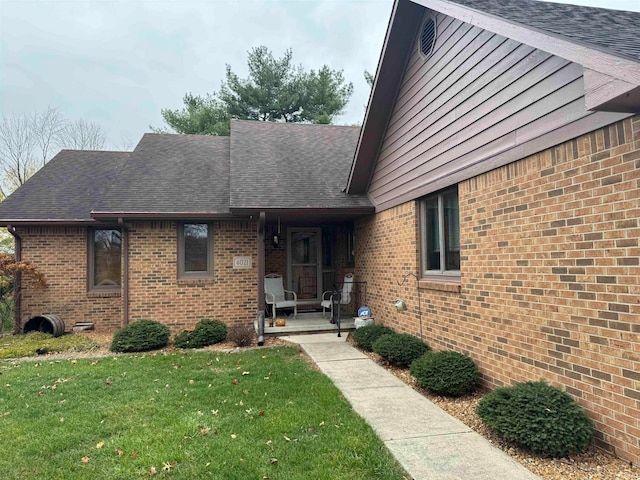 view of front of home with covered porch and a front lawn