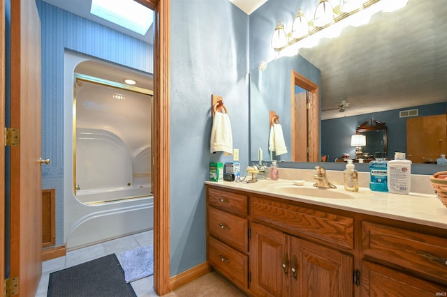 bathroom with tile patterned flooring, vanity, shower with separate bathtub, and a skylight