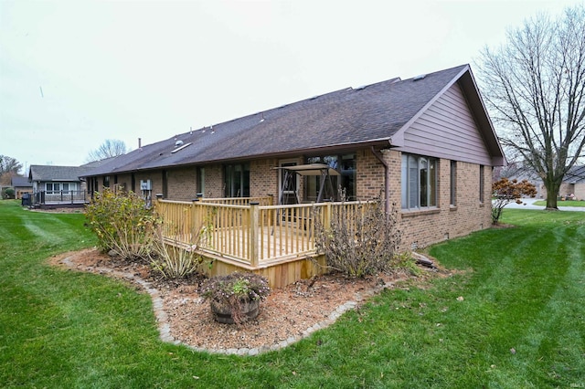 view of side of home featuring a wooden deck and a yard