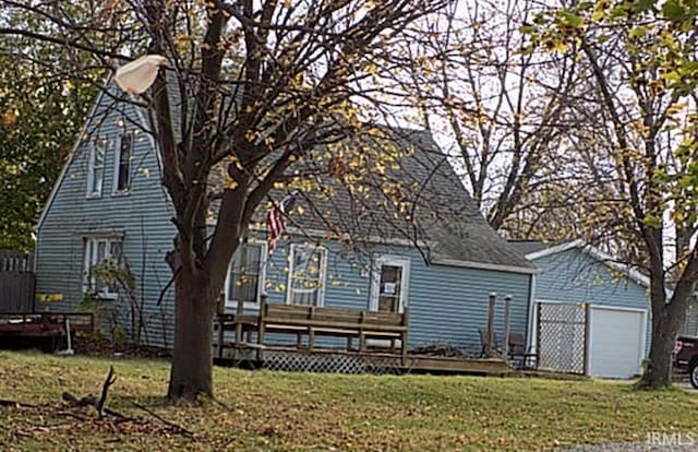 rear view of house featuring a garage, a yard, and a deck