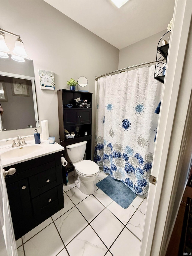 bathroom with toilet, vanity, and tile patterned flooring