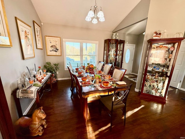 dining room featuring dark wood-type flooring, an inviting chandelier, and lofted ceiling