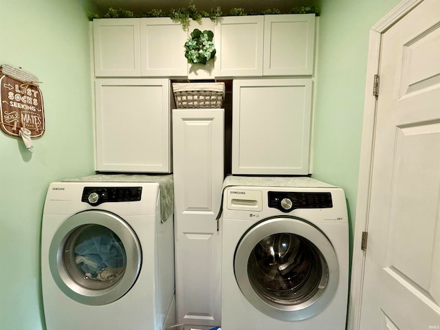 clothes washing area featuring separate washer and dryer and cabinets