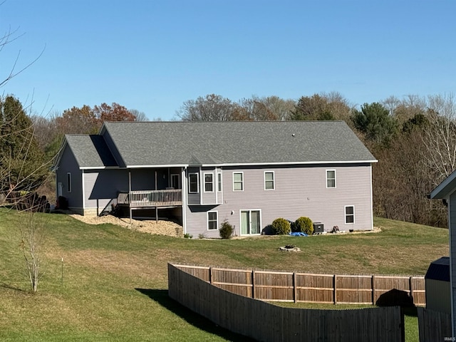 rear view of house featuring cooling unit and a yard