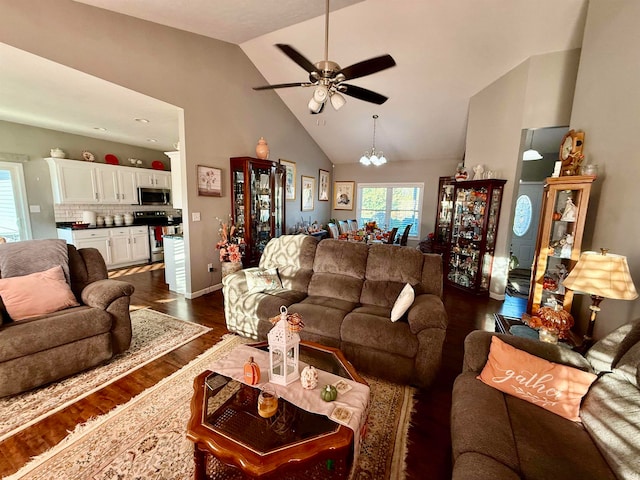 living room with dark hardwood / wood-style floors, high vaulted ceiling, and ceiling fan with notable chandelier