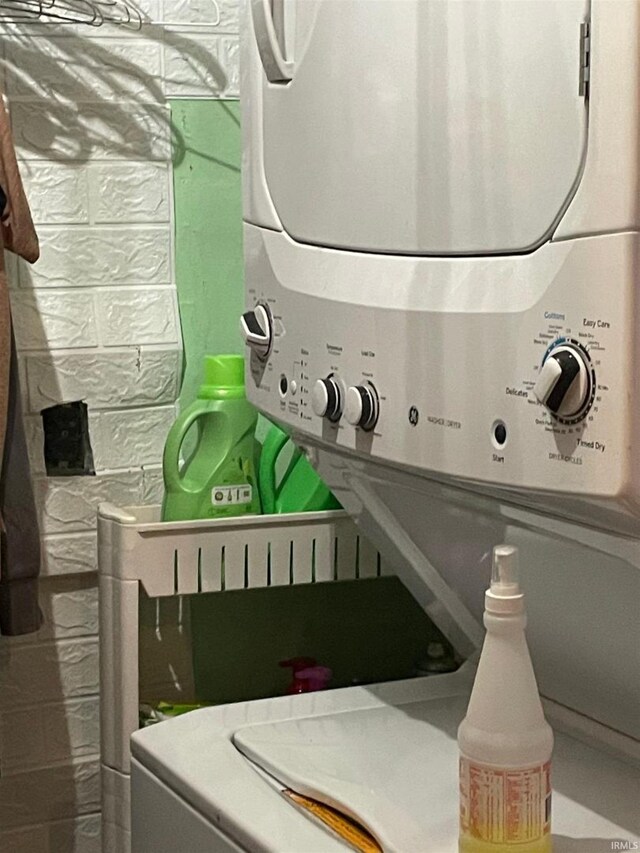 laundry area featuring stacked washer / drying machine