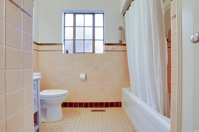 full bathroom featuring vanity, shower / bathtub combination with curtain, toilet, and tile walls