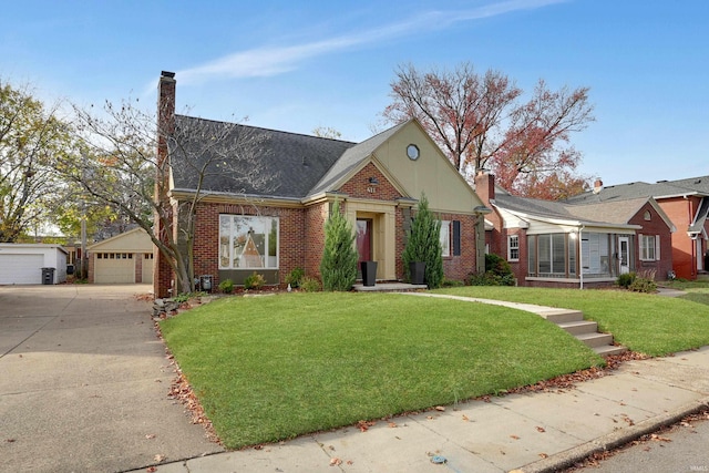 view of front of house with a garage, an outbuilding, and a front lawn