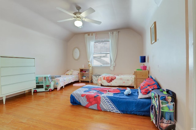 bedroom with hardwood / wood-style floors, vaulted ceiling, and ceiling fan