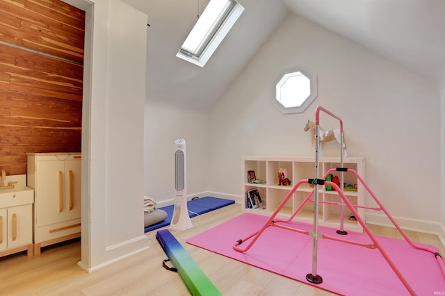 playroom featuring vaulted ceiling with skylight and hardwood / wood-style flooring