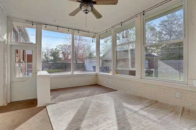 unfurnished sunroom with ceiling fan and a healthy amount of sunlight