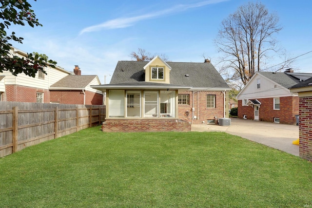 rear view of property featuring a yard and central AC unit