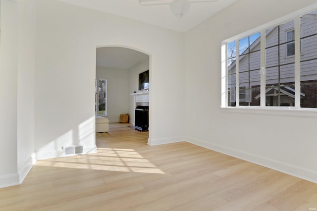 unfurnished room with ceiling fan and light wood-type flooring