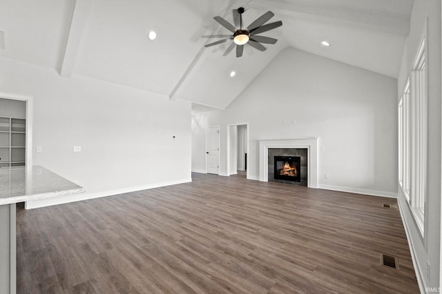 unfurnished living room with dark hardwood / wood-style flooring, high vaulted ceiling, beamed ceiling, ceiling fan, and a fireplace