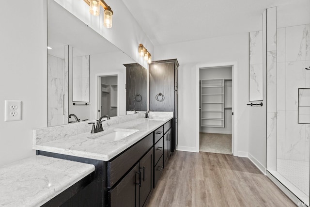 bathroom with vanity, hardwood / wood-style flooring, and a tile shower