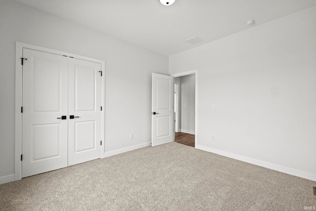 unfurnished bedroom with carpet flooring and a closet