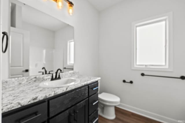 bathroom featuring wood-type flooring, vanity, and toilet