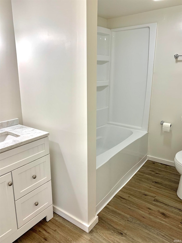 full bathroom featuring hardwood / wood-style floors, shower / bath combination, vanity, and toilet