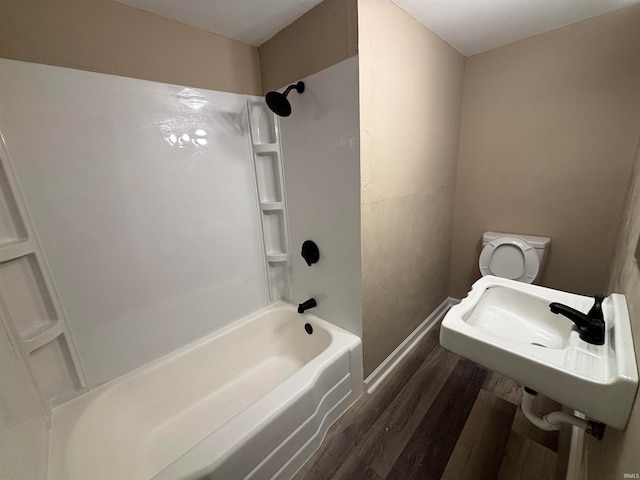 bathroom featuring toilet, tub / shower combination, and wood-type flooring