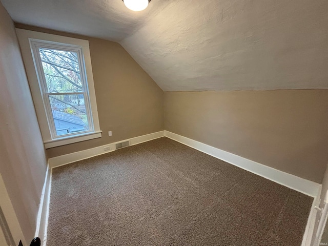 bonus room with vaulted ceiling and carpet