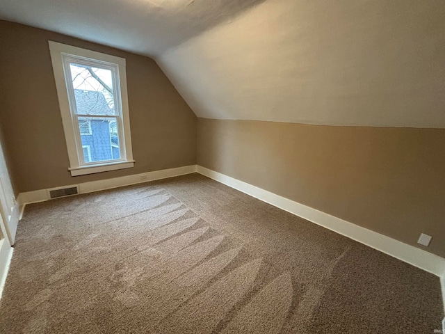 bonus room with carpet floors and vaulted ceiling