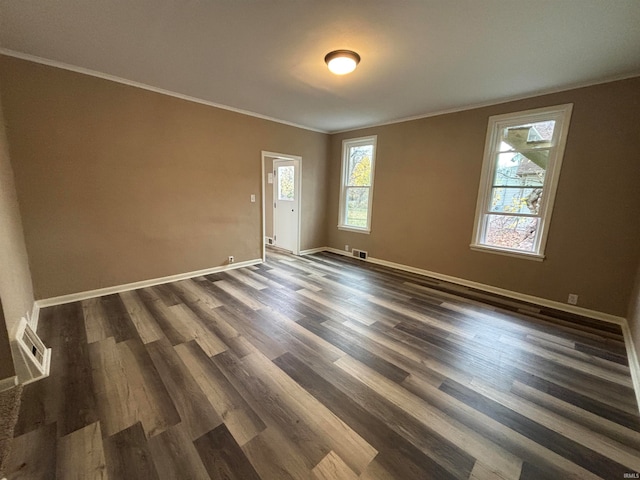 spare room with dark wood-type flooring and crown molding