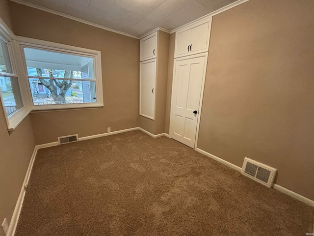 unfurnished bedroom with crown molding, a closet, and carpet floors