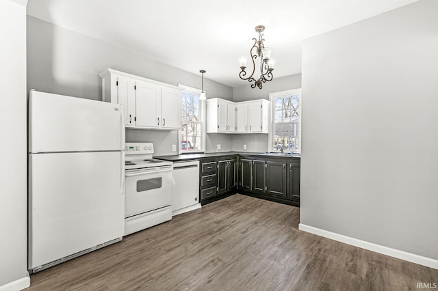 kitchen featuring a notable chandelier, hardwood / wood-style floors, decorative light fixtures, white appliances, and white cabinets