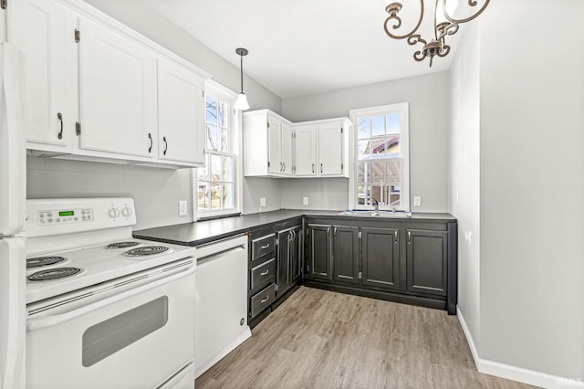 kitchen featuring white range with electric stovetop, white cabinetry, light wood-type flooring, and decorative light fixtures