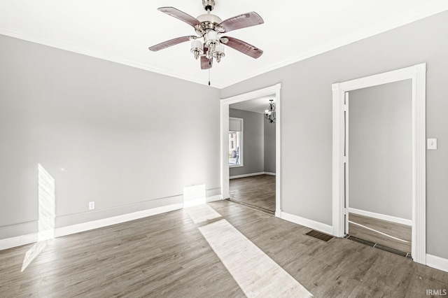 spare room with ceiling fan with notable chandelier, wood-type flooring, and ornamental molding