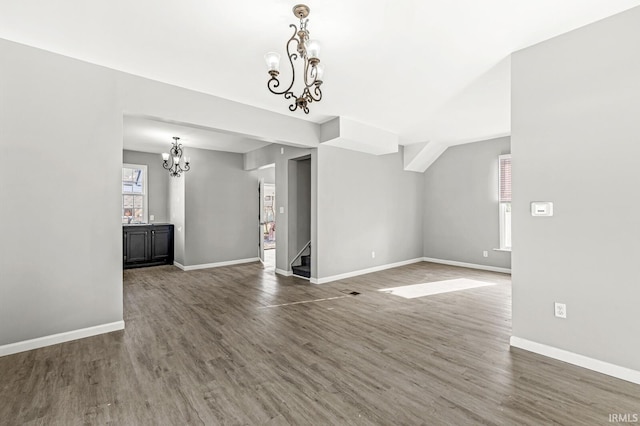 unfurnished living room featuring dark wood-type flooring and a chandelier