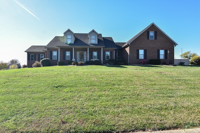 cape cod home featuring a front lawn