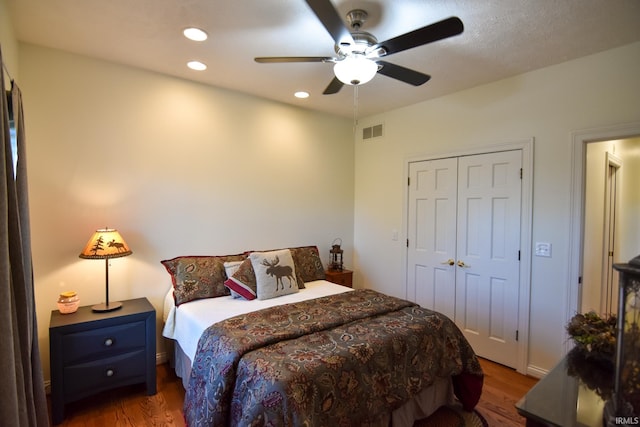 bedroom with a closet, ceiling fan, and dark hardwood / wood-style floors