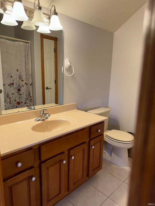 bathroom with toilet, vanity, and tile patterned floors