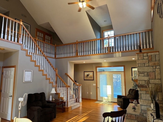 foyer entrance with light hardwood / wood-style floors, ceiling fan, plenty of natural light, and high vaulted ceiling