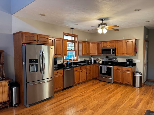 kitchen featuring ceiling fan, sink, light hardwood / wood-style floors, and stainless steel appliances