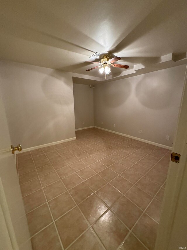 tiled empty room featuring ceiling fan