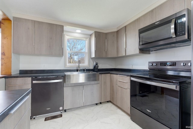 kitchen featuring light brown cabinetry, sink, and stainless steel appliances