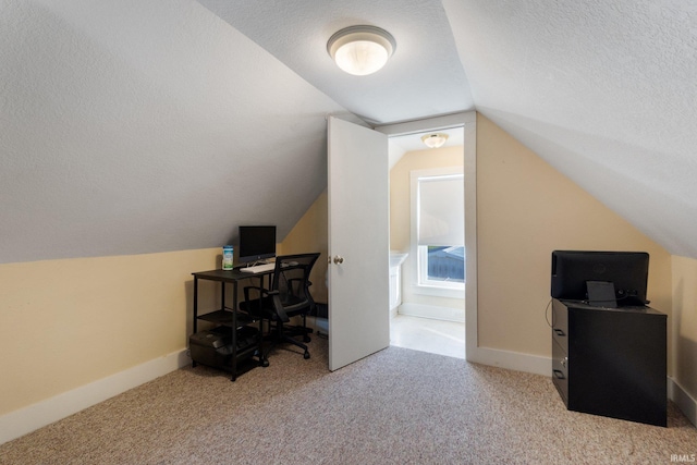 carpeted home office with lofted ceiling and a textured ceiling