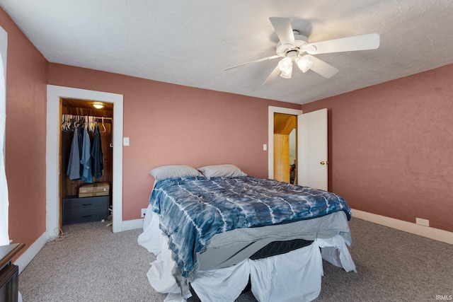 carpeted bedroom featuring ceiling fan, a spacious closet, a textured ceiling, and a closet