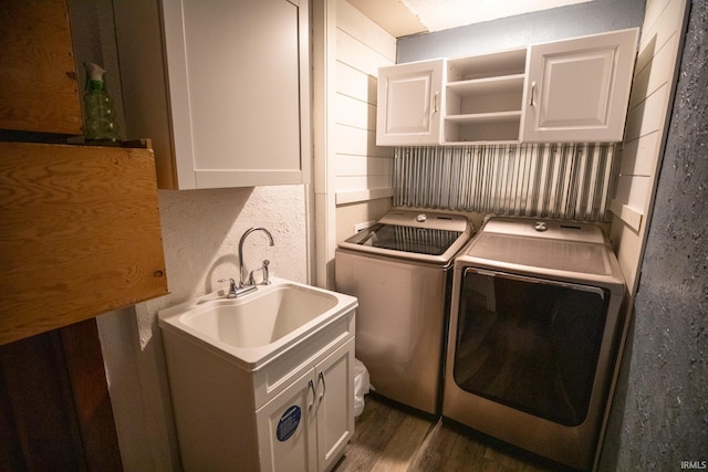 washroom featuring washer and dryer, cabinets, and dark wood-type flooring