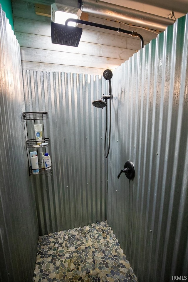 bathroom with wooden walls and walk in shower