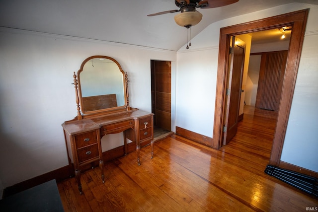 corridor with hardwood / wood-style floors and lofted ceiling