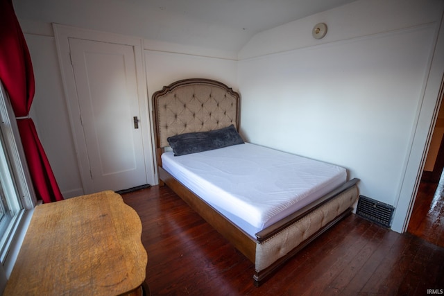 bedroom with dark wood-type flooring and vaulted ceiling