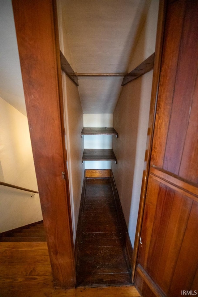 staircase featuring hardwood / wood-style flooring and vaulted ceiling