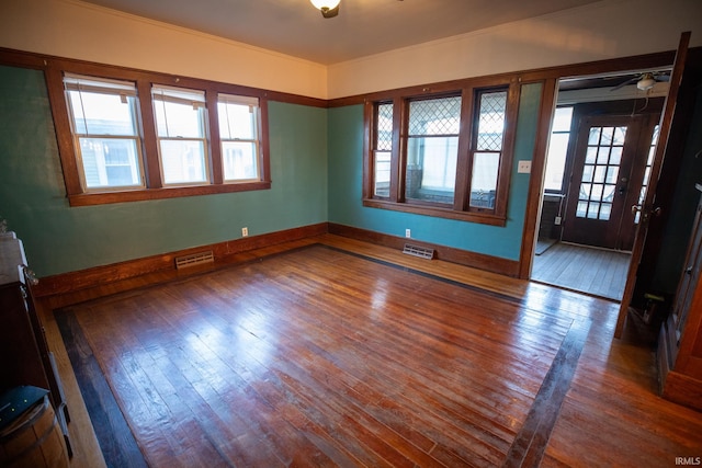 unfurnished room with ceiling fan, wood-type flooring, and a wealth of natural light