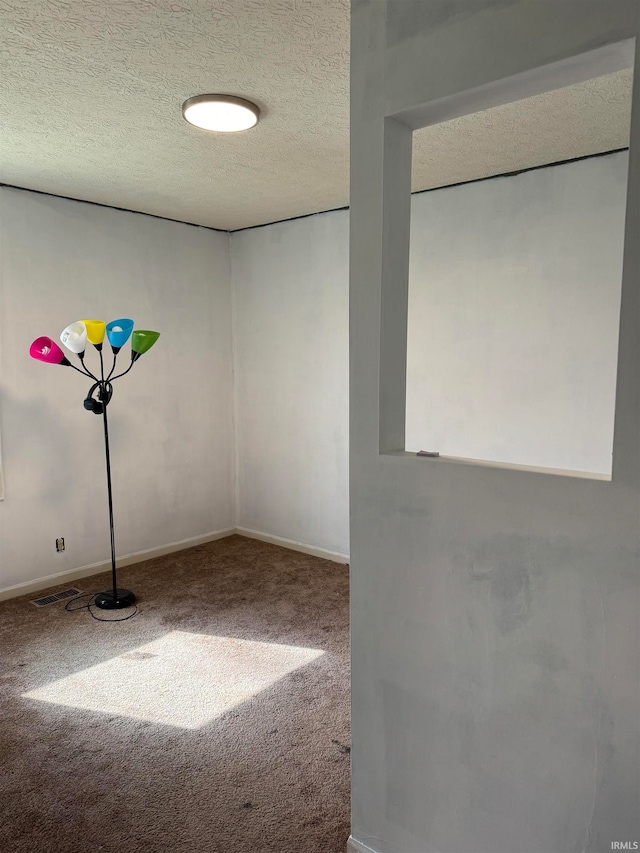 carpeted spare room featuring a textured ceiling