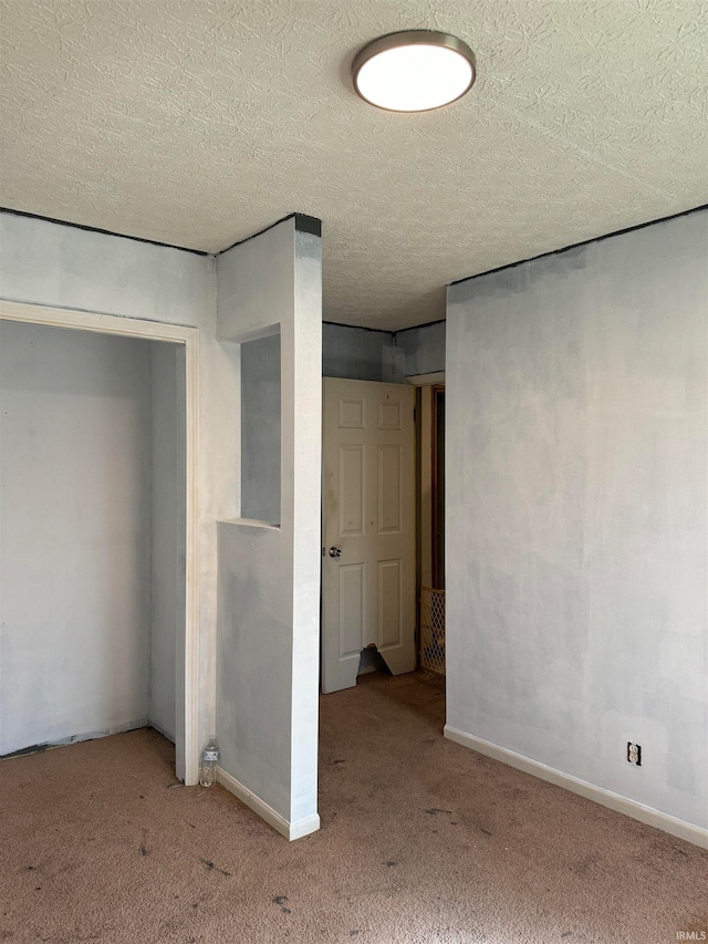 basement featuring a textured ceiling and light colored carpet