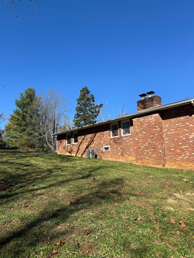 rear view of property with a lawn and central AC